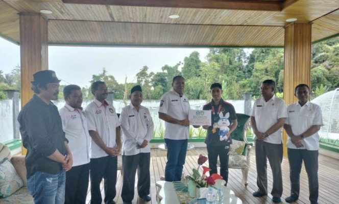 
 Bupati Halsel, Usman Sidik saat menyerahkan Bonus Rp.50 juta, kepada Asri Udin Peraih Medali Perunggu Sea Games Kamboja 2023.